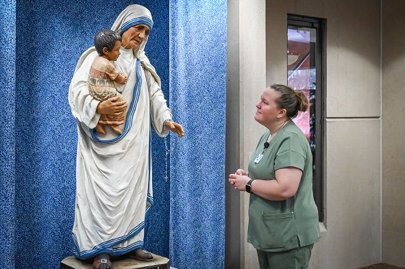 TEC volunteer Brittany Dulak by statue of Mother Teresa.
